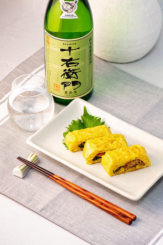 Juemon “Junmai,” with a sake glass, served with “Umaki” (a rolled, glazed eel omelet).