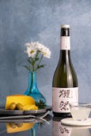 Dassai “45” Nigori Junmai Daiginjo, with a clear glass cup, served with gouda cheese and olives